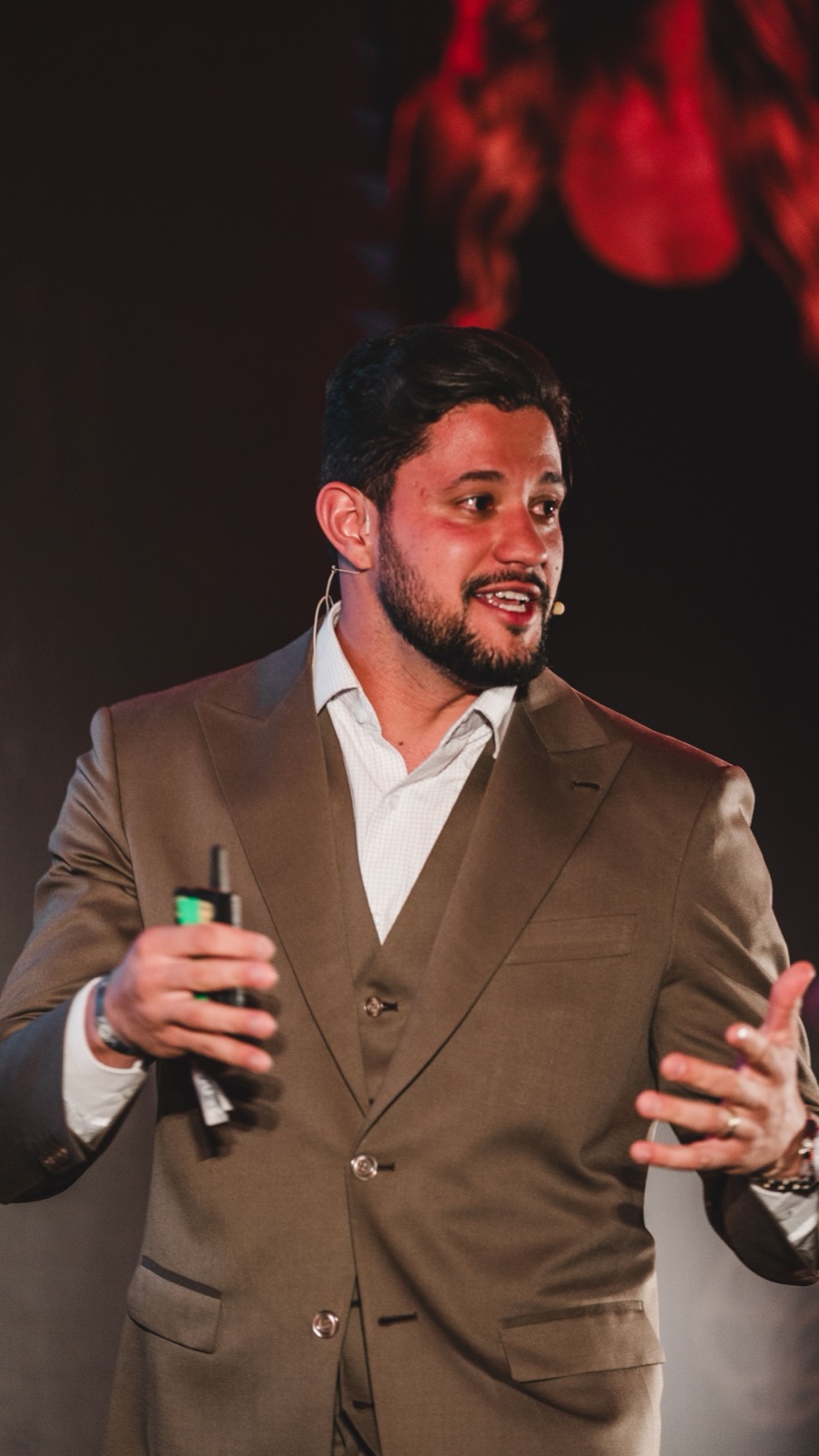 Vitor Rehbein de terno, com microfone, durante palestra sobre gestão financeira para clínicas