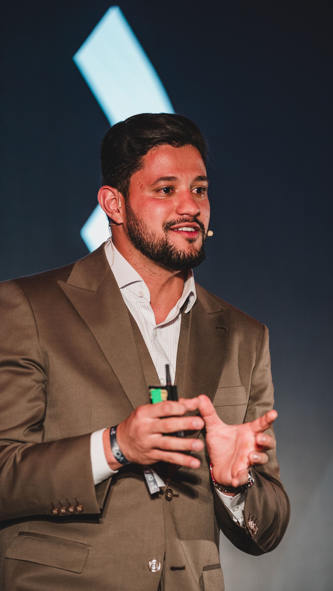 Vitor Rehbein falando no palco, mãos à frente do corpo